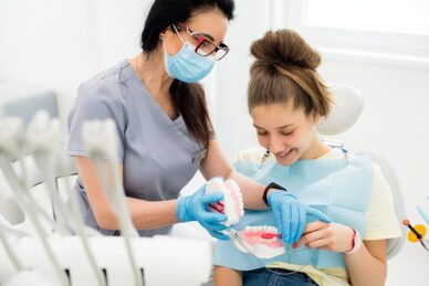 Lekarz ortodonta pokazuje dziewczynce wycisk zębów