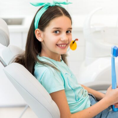 Uśmiechnięta dziewczynka na fotelu dentystycznym